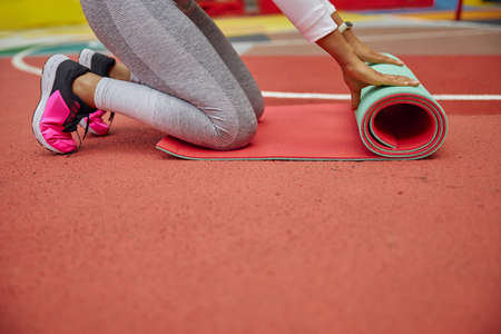 Beautiful healthy cheerful smily woman workout in an urban color city training squareの写真素材