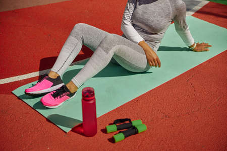 Beautiful healthy cheerful smily woman workout in an urban color city training square