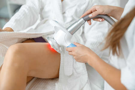 Beautiful healthy smiling caucasian woman is doing beauty procedures at spa and healthcare salonの写真素材