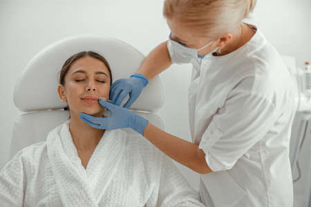Beautiful healthy smiling caucasian woman is doing beauty procedures at spa and healthcare salonの写真素材