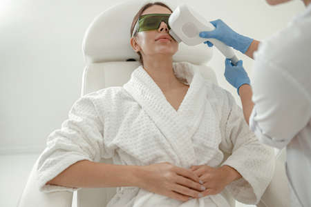 Beautiful healthy smiling caucasian woman is doing beauty procedures at spa and healthcare salonの写真素材