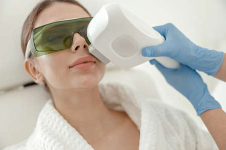 Beautiful healthy smiling caucasian woman is doing beauty procedures at spa and healthcare salonの写真素材