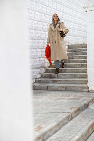 Mature pale hair stylish woman lifestyle portrait outdoors in cityの写真素材