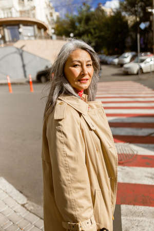 Mature pale hair stylish woman lifestyle portrait outdoors in cityの写真素材