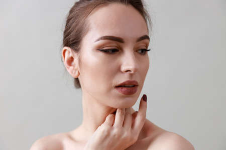 Studio beauty portrait of a young, healthy, beautiful, fresh skinned caucasian woman on a gray backgroundの写真素材