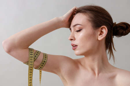 Studio beauty portrait of a young, healthy, beautiful, fresh skinned caucasian woman on a gray backgroundの写真素材