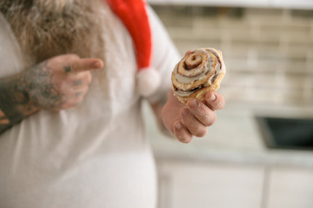 Emotional fat funny and tattooed man with food at the kitchen at homeの写真素材