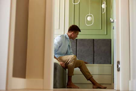 Young adult happy man in near olive wall is having time and smilingの写真素材