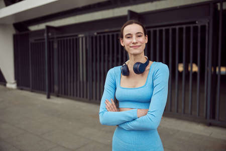 Slim young caucasian lady is doing sports outdoors in the urban place