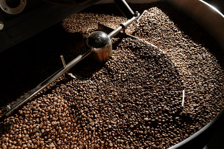 Coffee processing. Roastery, roasting machine and fresh beansの写真素材