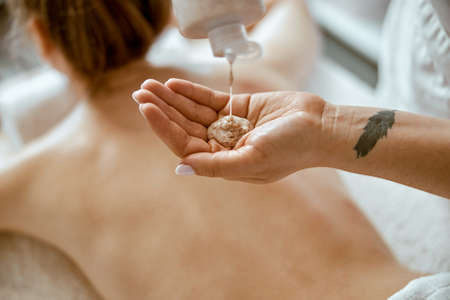 confident female specialist is doing relaxing body massage for beautyful slim caucasian lady at minimalistic spa salonの写真素材