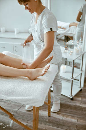 Confident female doctor is doing taping procedure in modenr treatment cabinetの写真素材