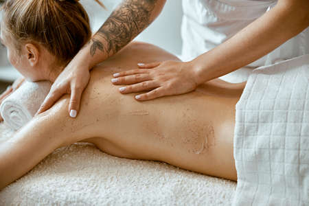 confident female specialist is doing relaxing body massage for beautyful slim caucasian lady at...