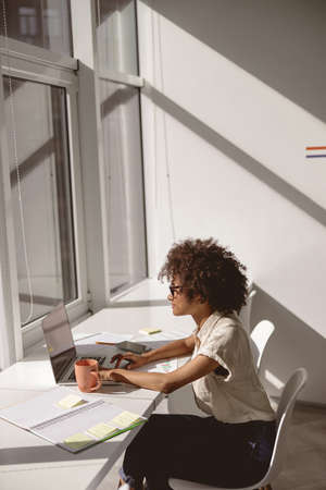 Smiling pretty woman looking at laptop screen during sunny day