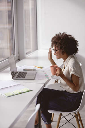 Happy Afro American lady waving hand during video conference