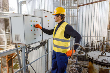 Male worker using control box at factory