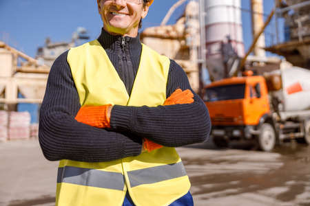 Cheerful man engineer standing outdoors at industrial site