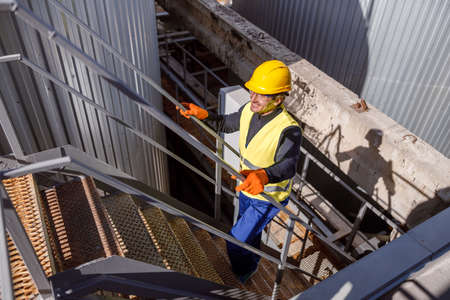 Joyful male worker climbing stairs at factory