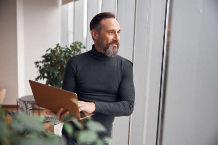 Happy adult caucasian man is working in a modern office