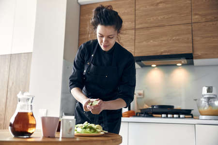 beautiful middle asian woman preparing apples for cooking at cozy stilysh kitchenの写真素材