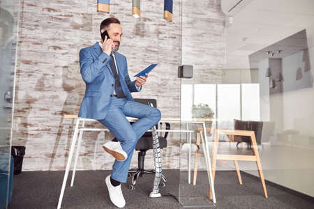 Happy adult caucasian man is working in a modern officeの写真素材