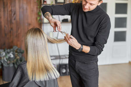 Hairdresser is choping hair of blonde woman is salonの写真素材