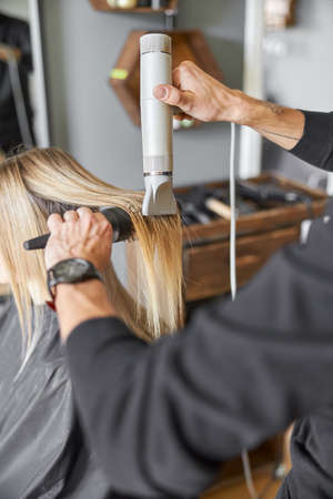 Hair drying process in modern hairdressers salonの写真素材