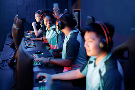 Young gamers playing online video game in cyber club