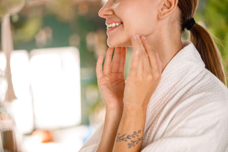 Closeup of young woman with beautiful smile and perfect skin enjoying beauty procedures, taking care...