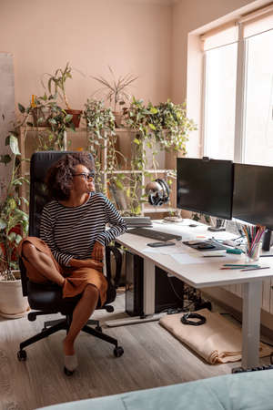 Multiethnic woman sitting at work table at homeの写真素材