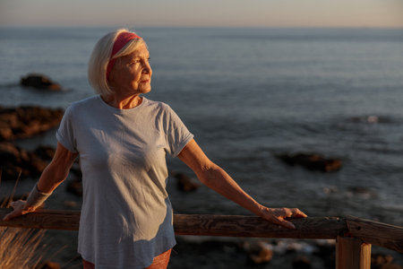 Attractive female pensioner breathing fresh air outdoorsの写真素材