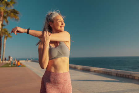Sporty strong woman training by the seashore
