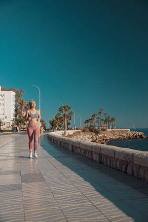 Slender athletic lady training by the waterfrontの写真素材