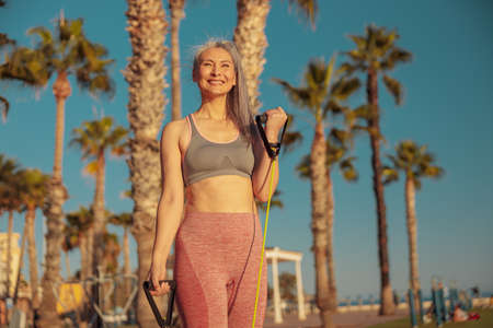Portrait of woman in sportswear exercising with fitness resistance bandsの写真素材