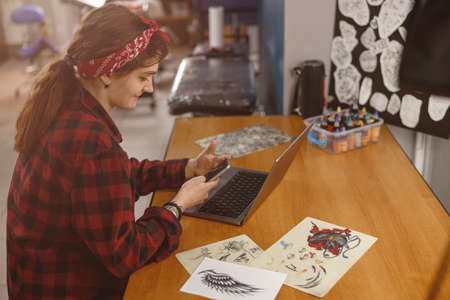 Portrait of smiling female tattoo artist sitting in tattoo salonの写真素材