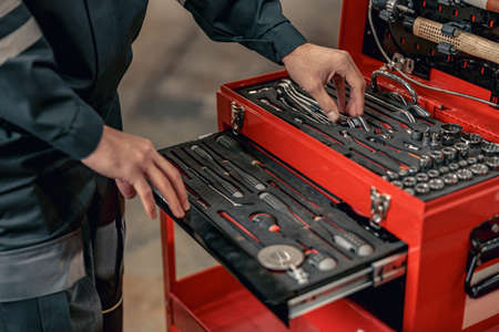 Male mechanic using tool box in hangar