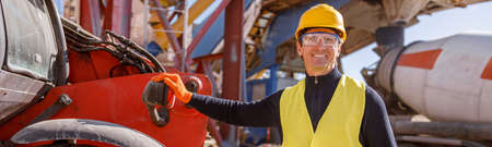 Joyful male worker standing by vehicle at factory