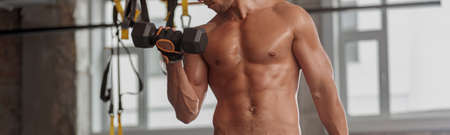 Athletic strong man exercising actively in the gym