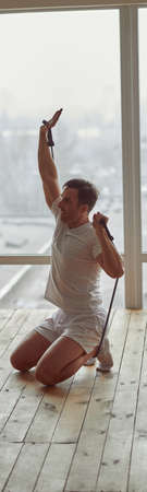 Determned guy doing training indoors during quarantineの写真素材