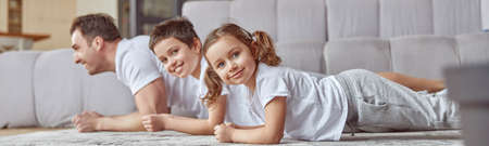 Happy children doing training with father at homeの写真素材