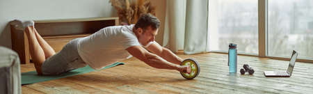 Man doing training with equipment and laptop indoors