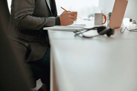 Office worker sitting at desk and holding penの写真素材