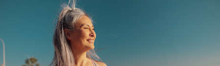 Strong slender woman standing by the waterfrontの写真素材