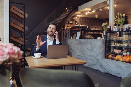 Handsome Caucasian elegant man talking about business on cellphone and having coffee.の写真素材