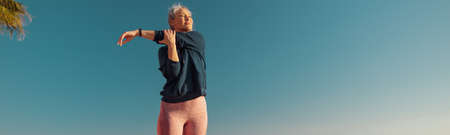 Woman exercising on warm day by the coast