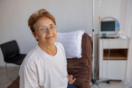 Smiling senior female patient in the ward of modern medical clinic