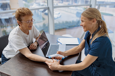 Doctor measures patients temperature with non-contact thermometer during an appointment