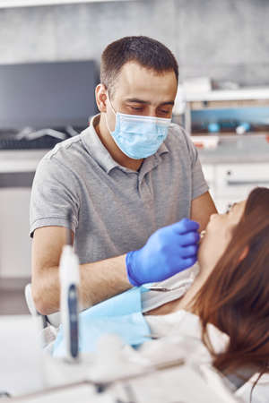 Professional doctor is choosing a colour of teeth in modern dental clinicの写真素材