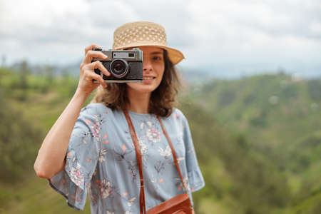 Smiling female travele using photo camera and making photoの写真素材