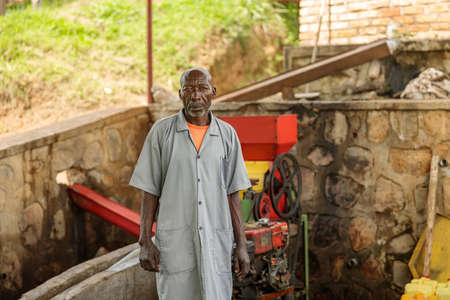 Elderly worker standing near the equipment at washing stationの写真素材